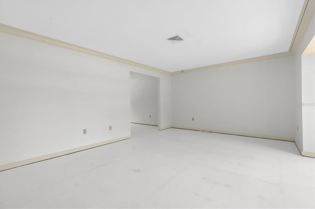 An empty room with white walls, crown molding, and a light-colored floor — 14373 82ND TERRACE, SEMINOLE, FL