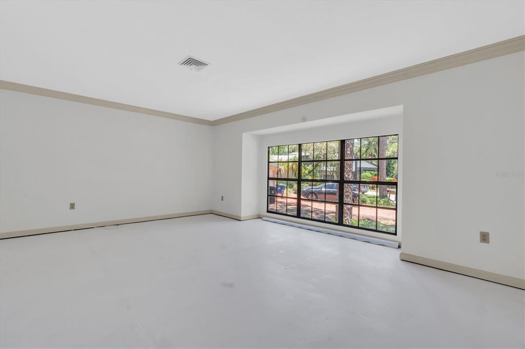 An empty room with white walls, beige trim, and a large grid-patterned window — 14373 82ND TERRACE, SEMINOLE, FL