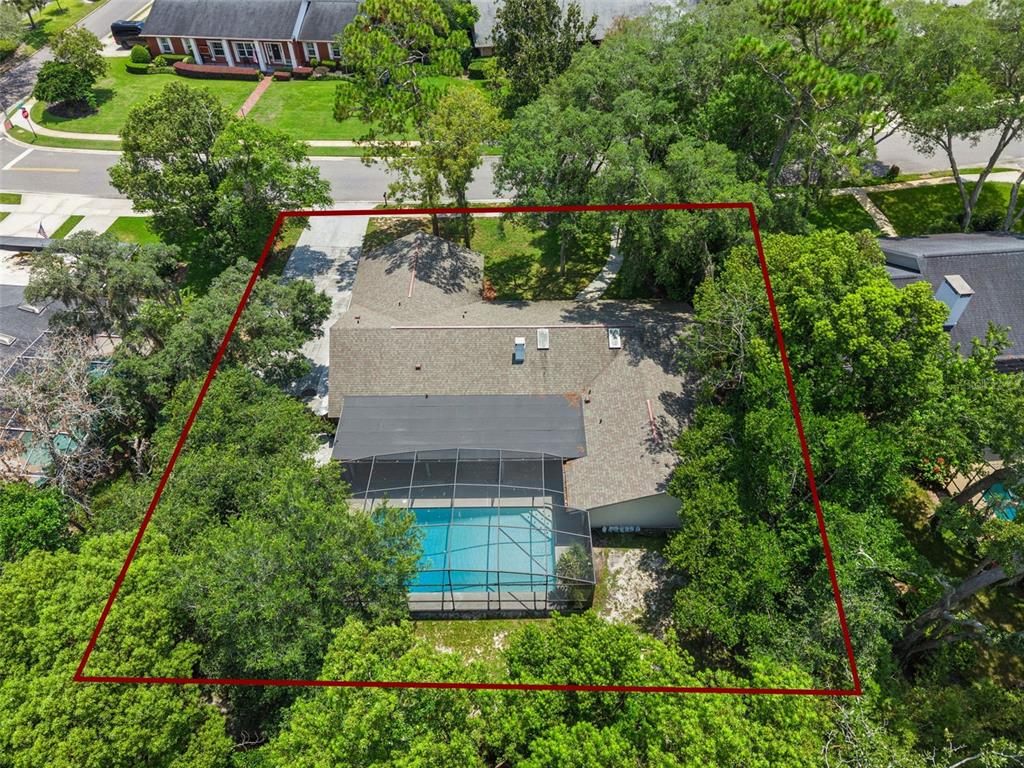 An aerial view shows a house with a screened-in pool surrounded by mature trees — 102 STONEBRIDGE DRIVE, LONGWOOD, FL