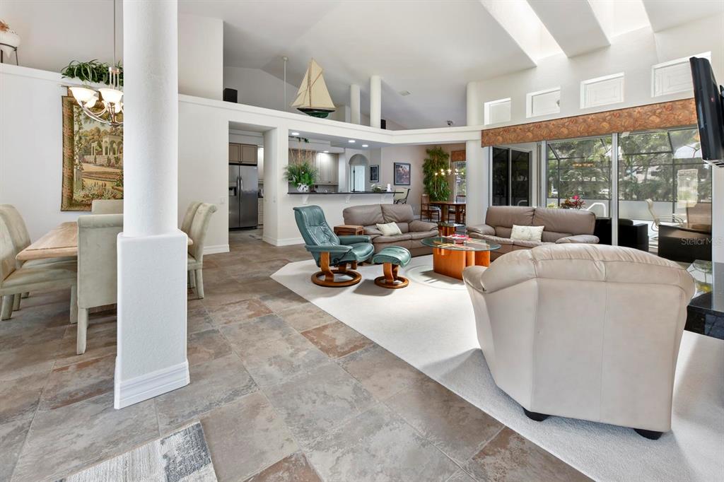An open-concept living and dining area features vaulted ceilings, tile flooring, and a neutral palette — 3267 SUGARLOAF KEY ROAD, PUNTA GORDA, FL