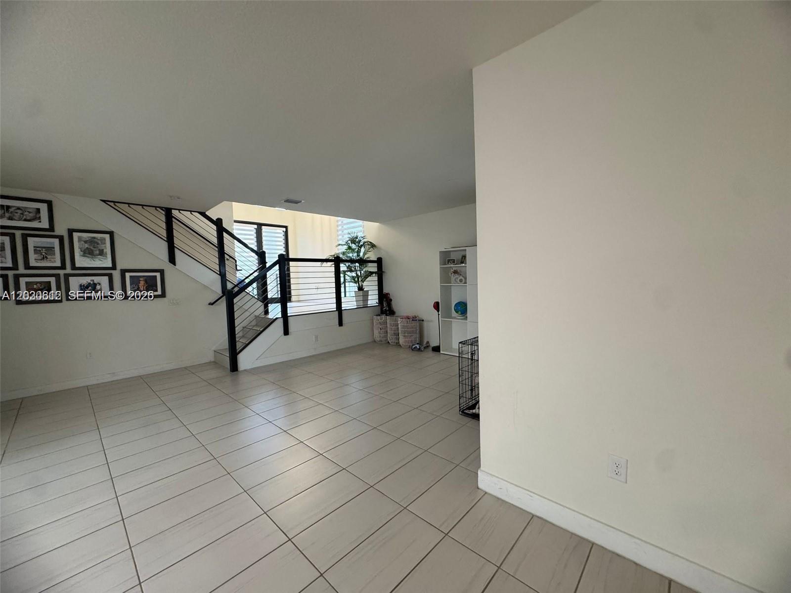 A tiled room features a staircase with black railings and a white bookshelf — 10240 NW 76th Ter, Doral FL 33178, DORAL, FL
