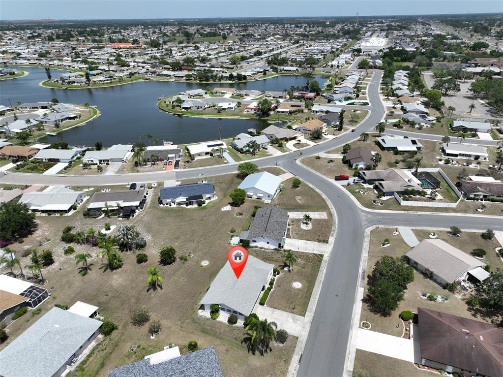 An aerial view shows a residential neighborhood with houses surrounding a large lake — 1809 HAVERFORD AVENUE, SUN CITY CENTER, FL