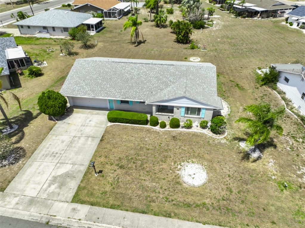 A single-story house with a gray roof, brick exterior, and a large front lawn — 1809 HAVERFORD AVENUE, SUN CITY CENTER, FL