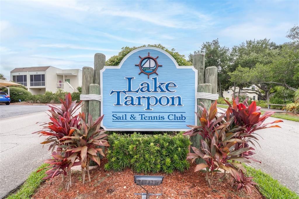 A sign for the Lake Tarpon Sail & Tennis Club stands in a landscaped area — 90 S HIGHLAND AVENUE UNIT 110, TARPON SPRINGS, FL