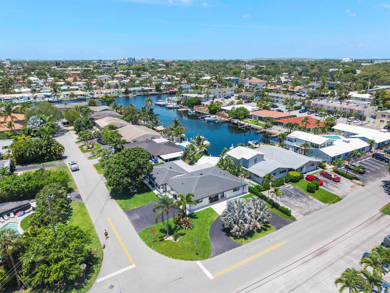 An aerial view shows a residential neighborhood with a canal, houses, and paved streets — 491 SE 19th Avenue, Pompano Beach FL 33060, POMPANO BEACH, FL
