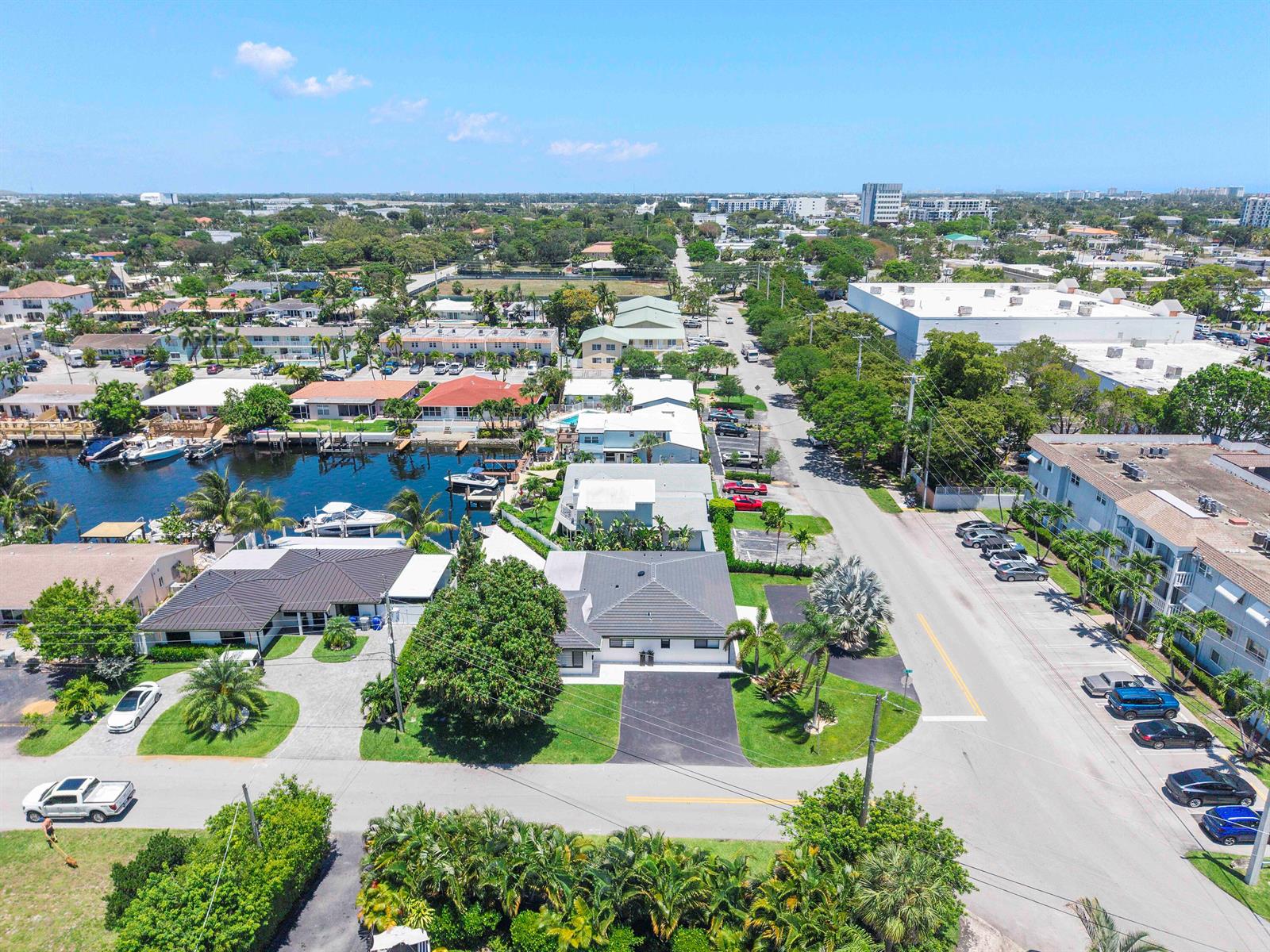 An aerial view shows a residential neighborhood with houses, a canal, and parked cars — 491 SE 19th Avenue, Pompano Beach FL 33060, POMPANO BEACH, FL