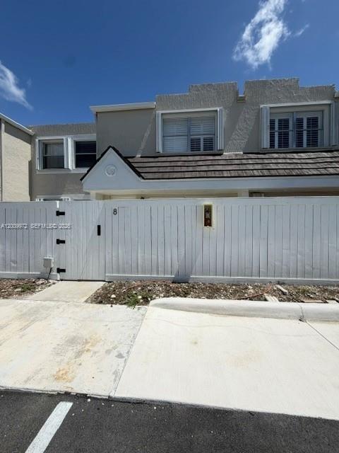 A two-story townhouse exterior features a white privacy fence and a concrete driveway — 4590 SW 68th Ct Cir # 8, Miami FL 33155, MIAMI, FL