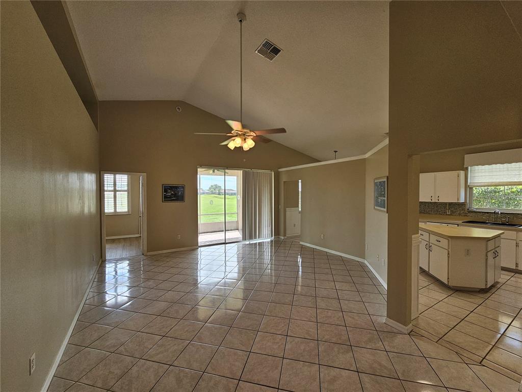 A spacious living area with vaulted ceilings, tile flooring, and a view of the outdoors — 17817 SE 115TH COURT, SUMMERFIELD, FL