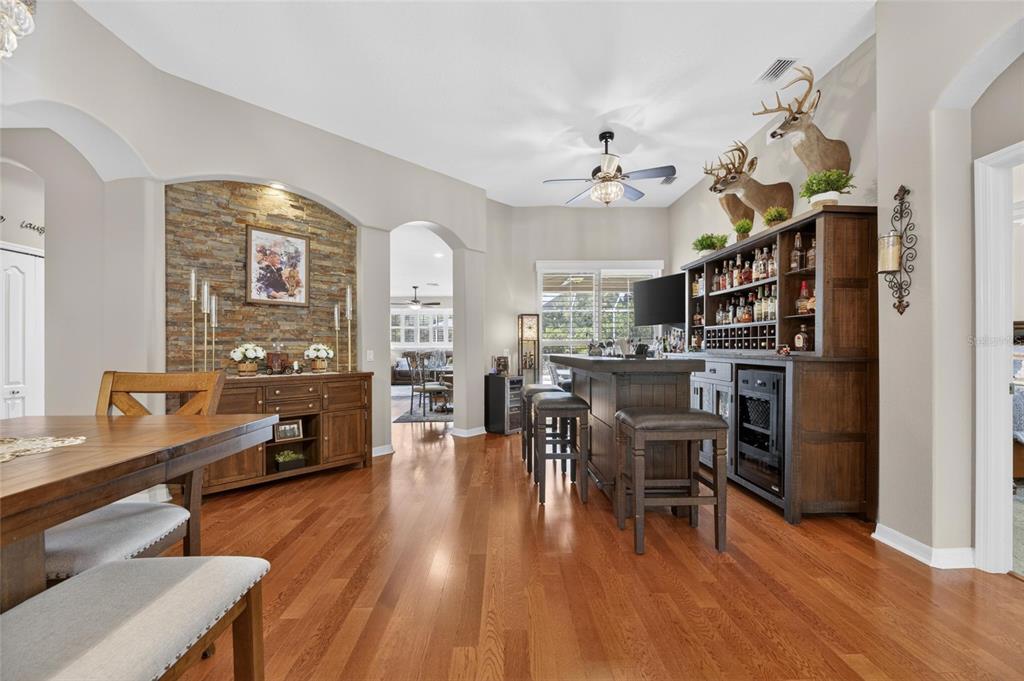 A dining area features a stone accent wall, a wooden bar, and hardwood flooring — 18116 KARA CT, TAMPA, FL