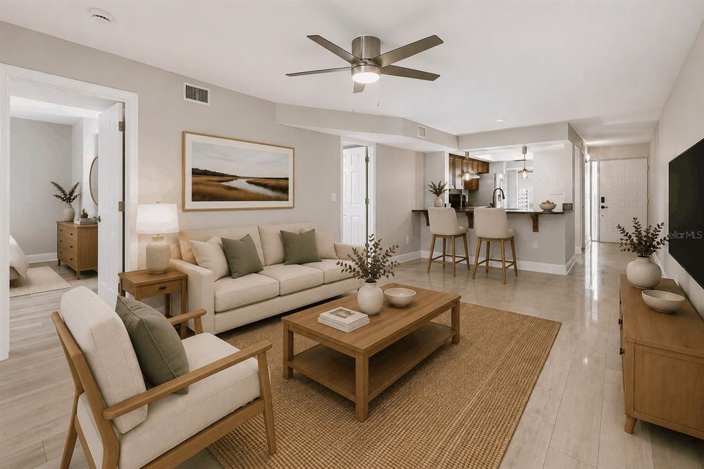 A living room with a sofa, coffee table, and an open kitchen with bar seating — 3157 LANDMARK DRIVE UNIT 414, CLEARWATER, FL