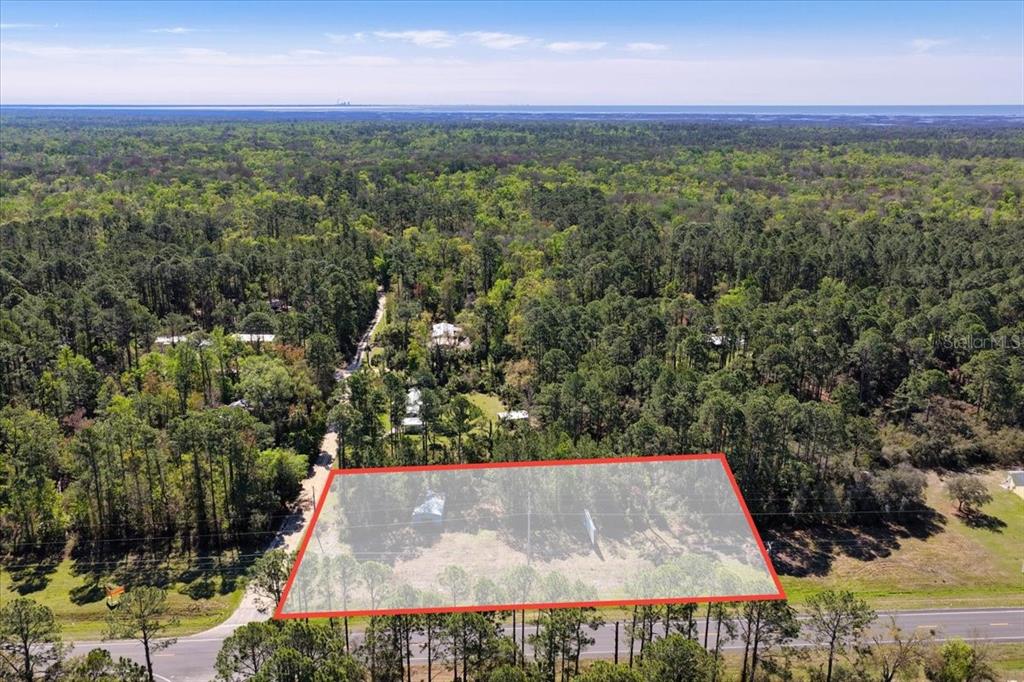 An aerial view shows a rectangular plot of land outlined in red near a road — TBD SW STATE ROAD 24, CEDAR KEY, FL
