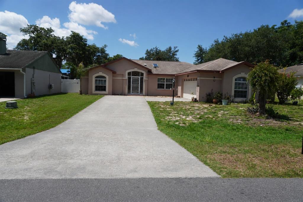 A single-story house with a concrete driveway, a two-car garage, and a front entrance — 11130 FOUNTAIN LAKE BOULEVARD, LEESBURG, FL