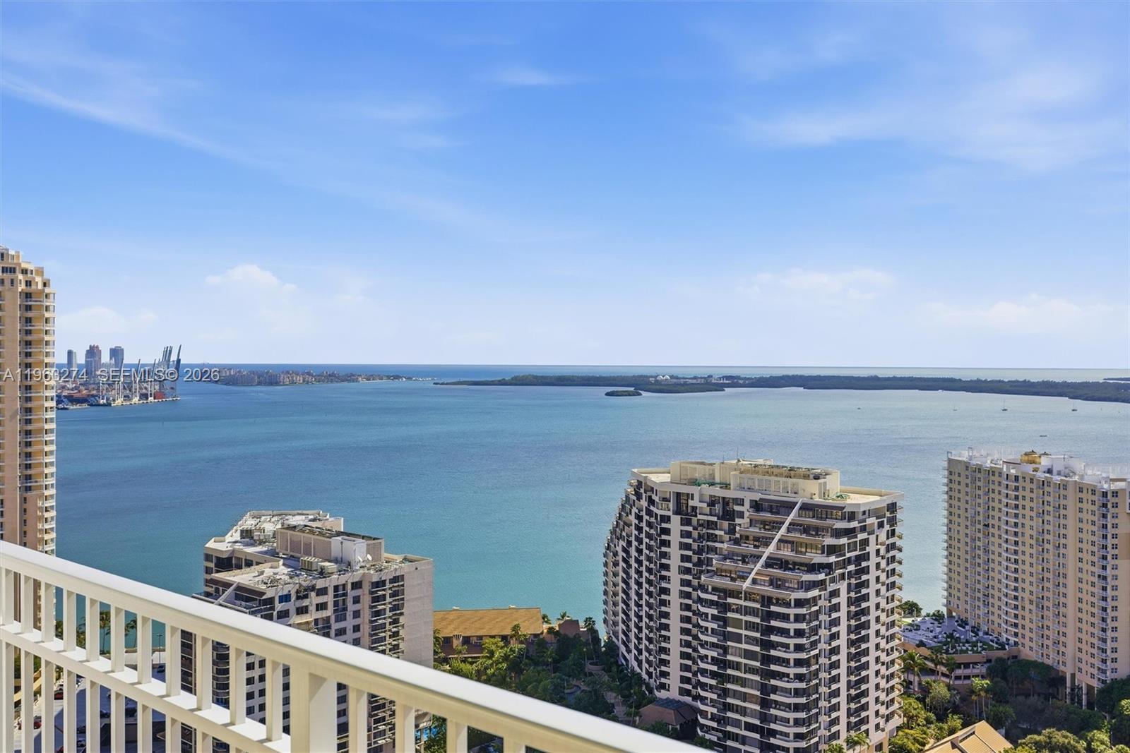 A high-angle view from a balcony overlooking a bay with several high-rise buildings — 801 Brickell Key Blvd # 3209, Miami FL 33131, MIAMI, FL
