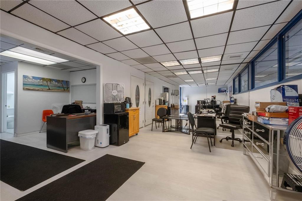 A commercial office space features a drop ceiling, white walls, and multiple desks and chairs — 1820 NE 2ND STREET, GAINESVILLE, FL