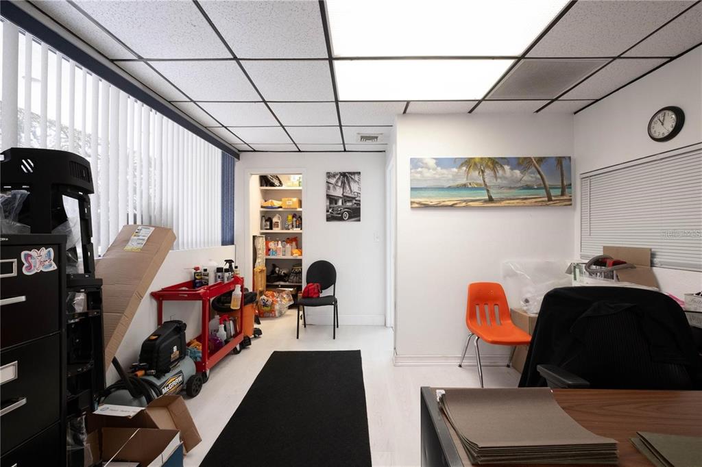 A room with a drop ceiling, white walls, a storage closet, and office furniture — 1820 NE 2ND STREET, GAINESVILLE, FL