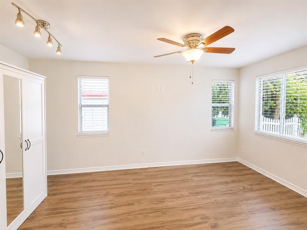 An empty bedroom features light wood-look flooring, a ceiling fan, and a white wardrobe — 1915 W ORIENT STREET, TAMPA, FL