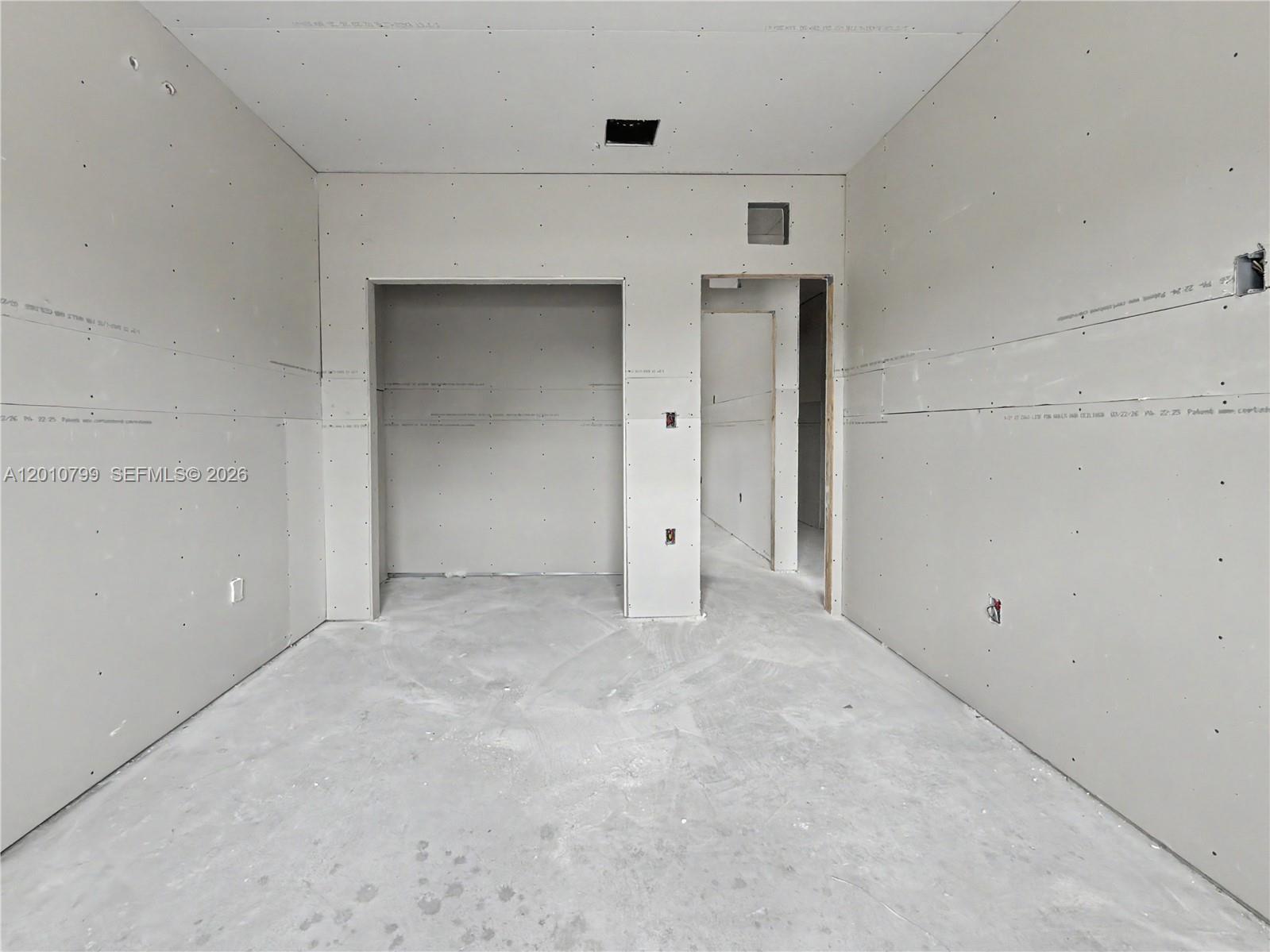 An unfinished room features gray drywall, exposed concrete floors, and two open doorways — 640 SW 10th Ave, Homestead FL 33030, HOMESTEAD, FL