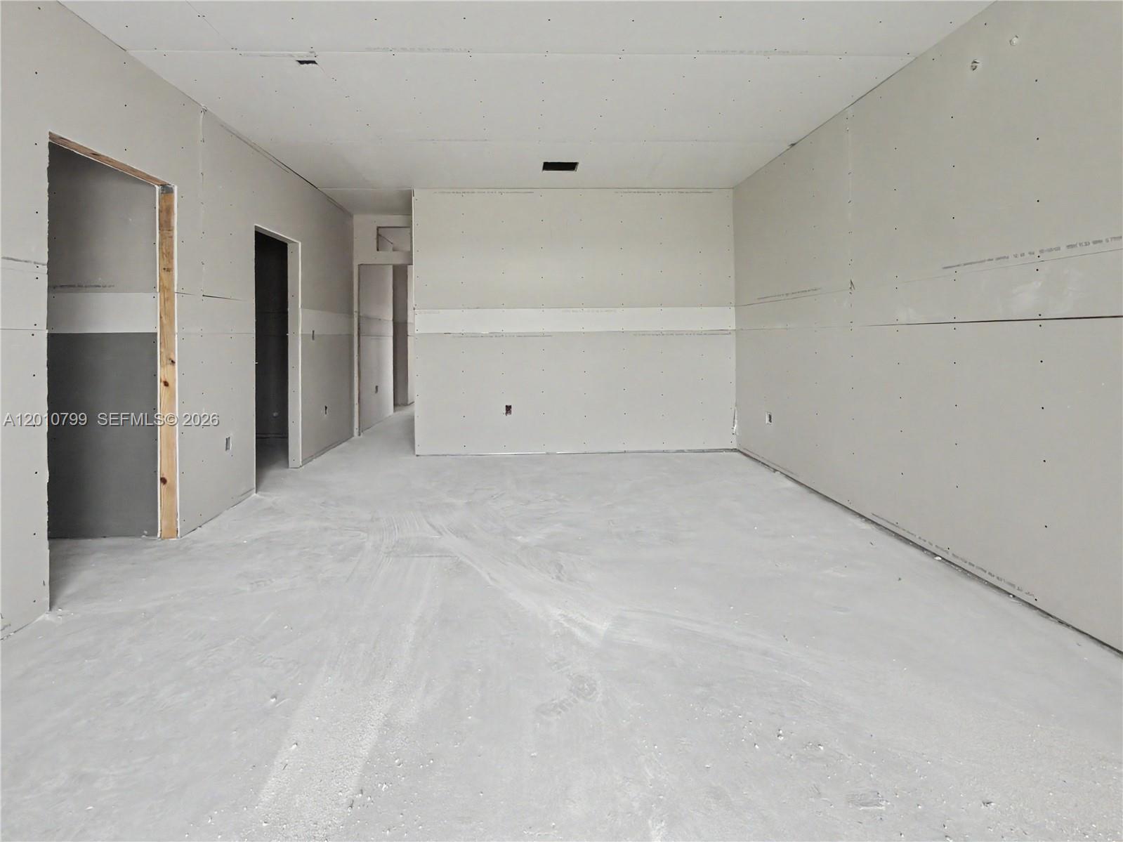An unfinished room features bare drywall walls, a concrete floor, and multiple open doorways — 640 SW 10th Ave, Homestead FL 33030, HOMESTEAD, FL