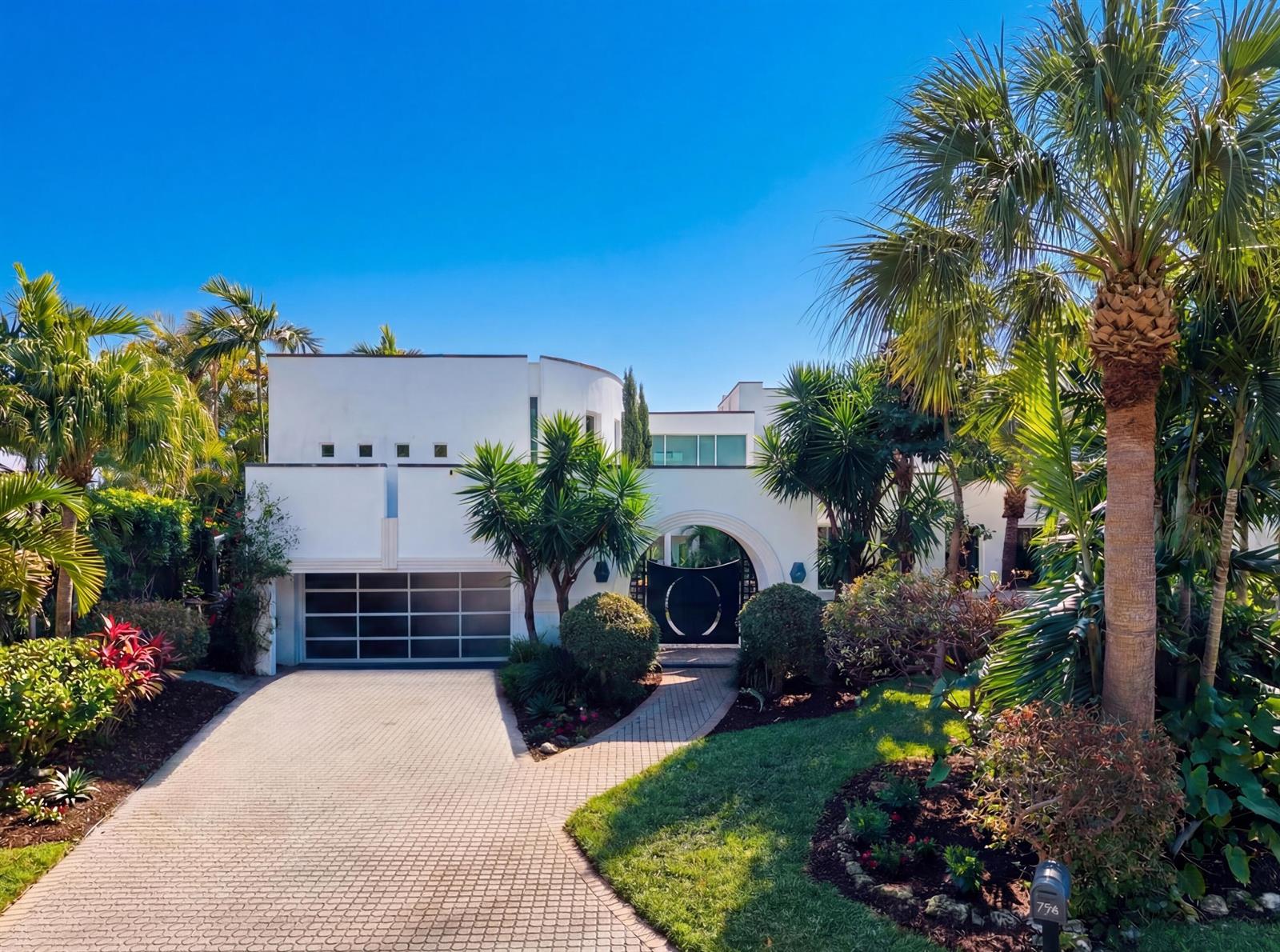 A modern white two-story house with a garage, arched entryway, and lush tropical landscaping — 794 Staghorn Court, Boca Raton FL 33432, BOCA RATON, FL