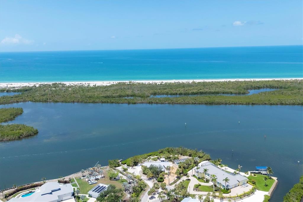 An aerial view shows a waterfront property with a large house, pool, and coastal vegetation — 55 GREEN DOLPHIN DRIVE N, PLACIDA, FL