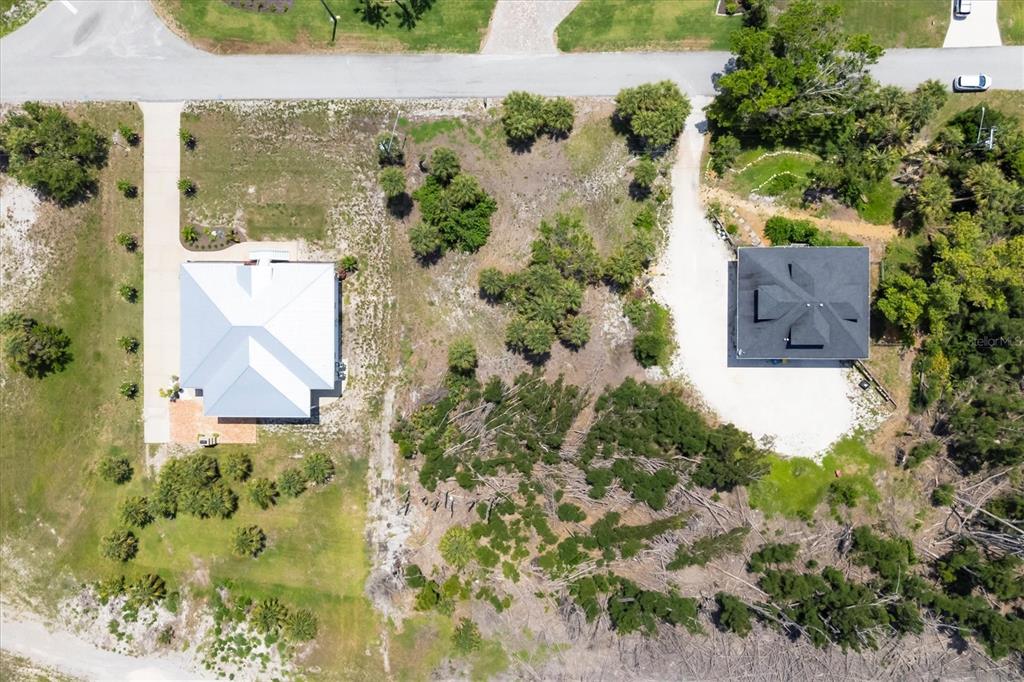 An aerial view shows two houses with driveways separated by a large, partially wooded lot — 55 GREEN DOLPHIN DRIVE N, PLACIDA, FL