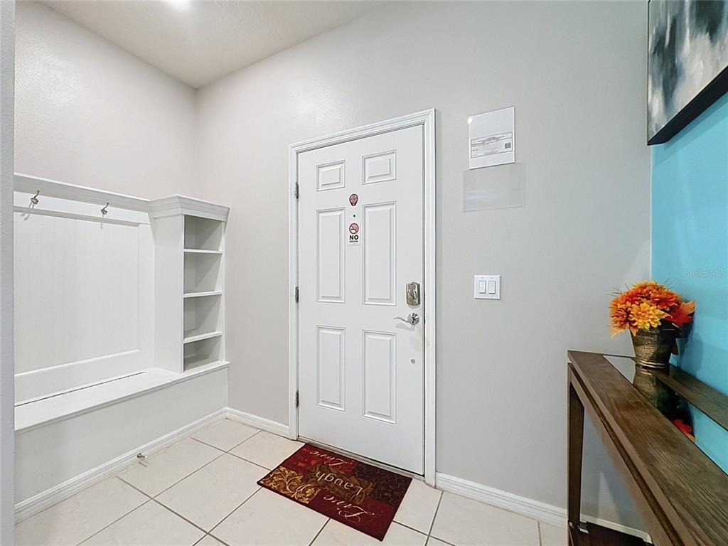 An entryway features a white door, a built-in bench with shelving, and a console table — 267 JETTY WAY, DAVENPORT, FL