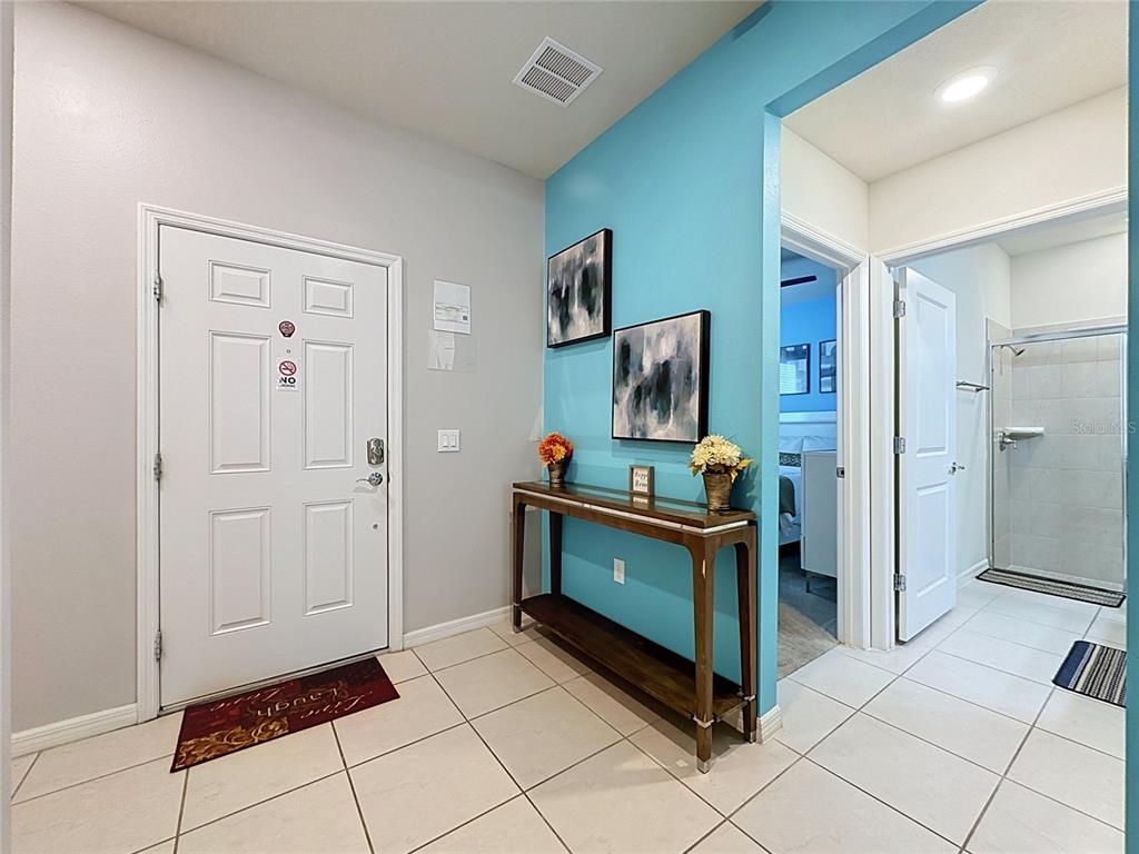 An entryway features a white front door, a blue accent wall, and a console table — 267 JETTY WAY, DAVENPORT, FL