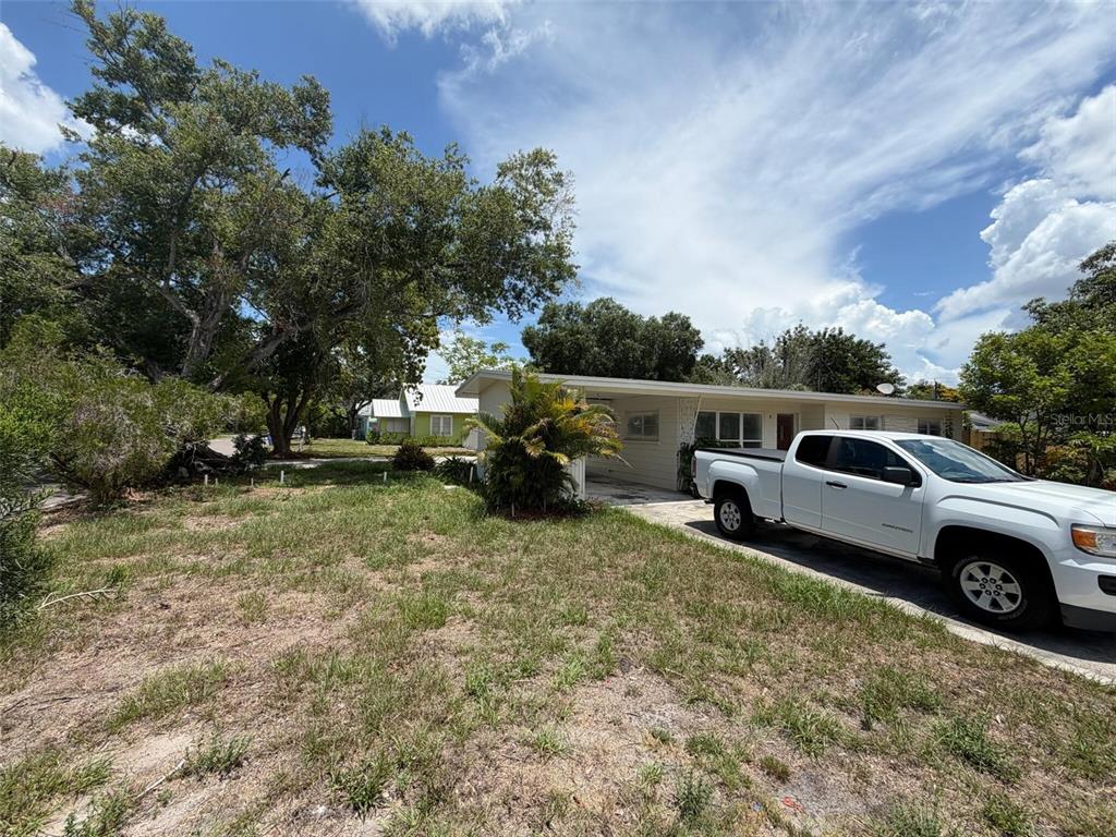 A white pickup truck is parked in the driveway of a single-story house with trees — 2612 9TH, BRADENTON, FL