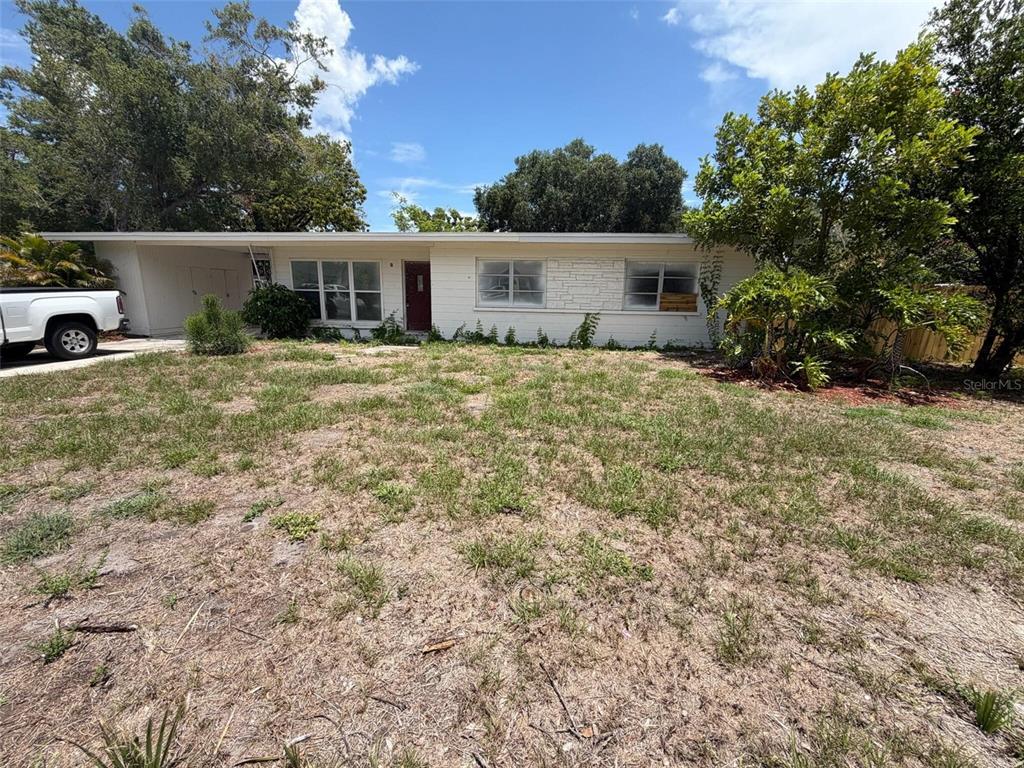 A single-story white house with a carport and a large, dry grassy front yard — 2612 9TH, BRADENTON, FL