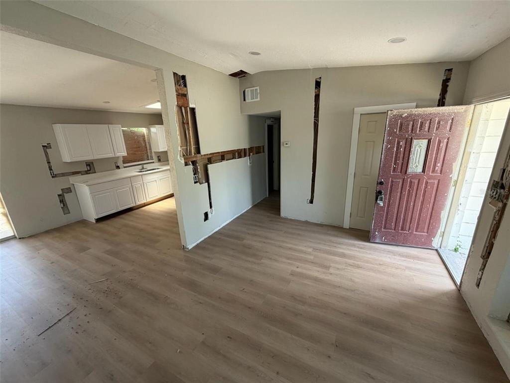 An interior view showing a living area with light wood flooring and unfinished wall sections — 2612 9TH, BRADENTON, FL
