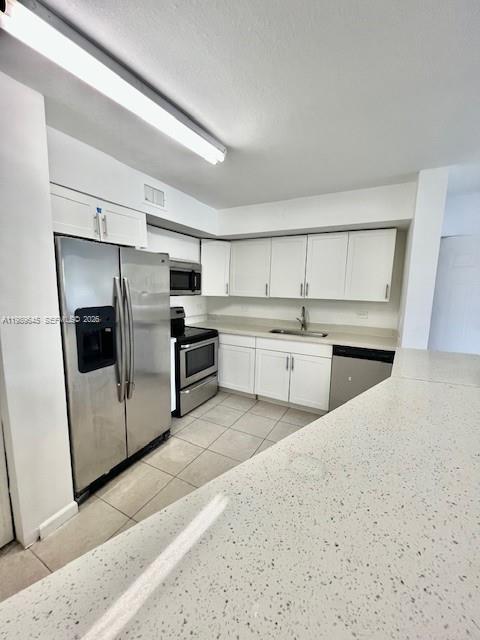 A kitchen features white cabinets, stainless steel appliances, and a light-colored countertop — 3690 N 56th Ave # 902, Hollywood FL 33021, HOLLYWOOD, FL