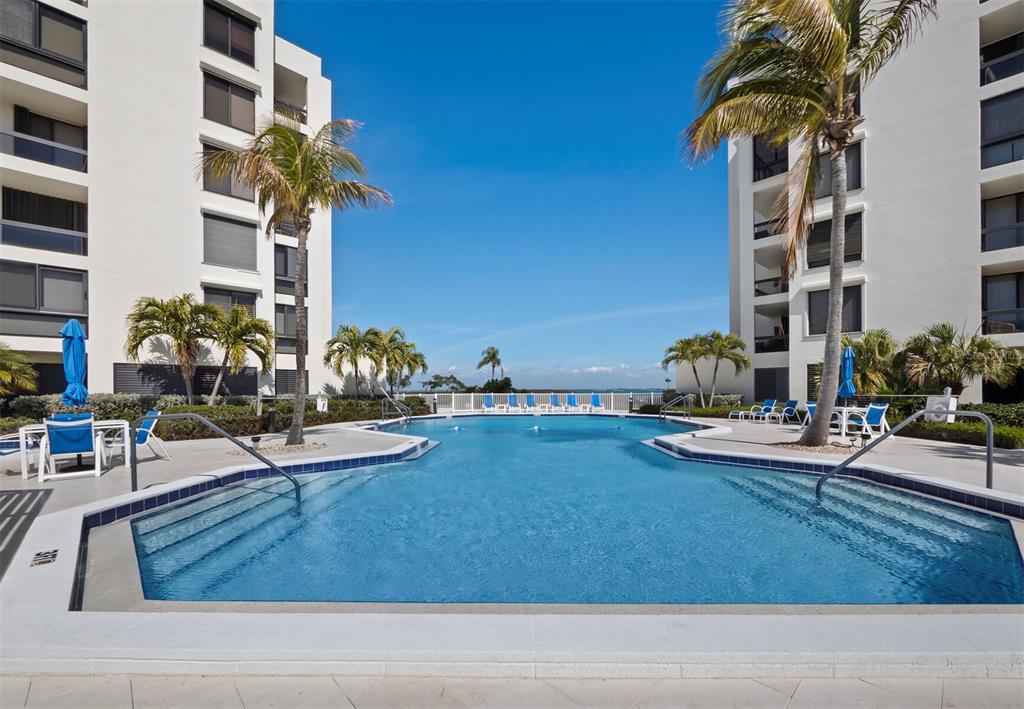 A living room features a vaulted ceiling, a fireplace, and large windows overlooking a marina — 1906 HARBOURSIDE DRIVE UNIT 304, LONGBOAT KEY, FL