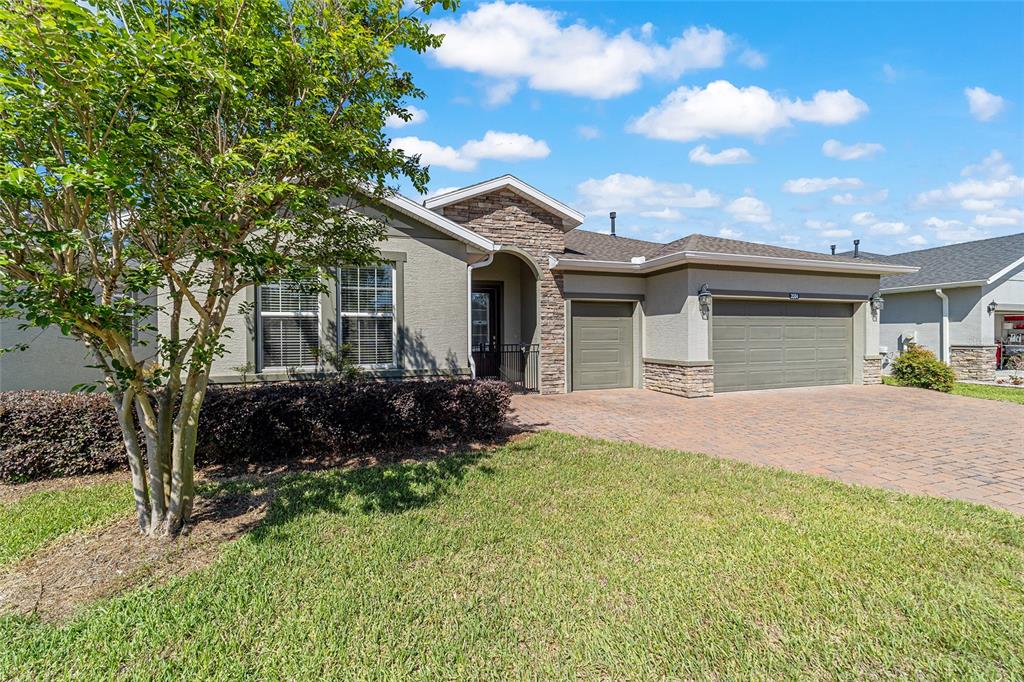A single-story house with a stone-accented facade, a paved driveway, and an attached garage — 3584 NW 56TH AVENUE, OCALA, FL