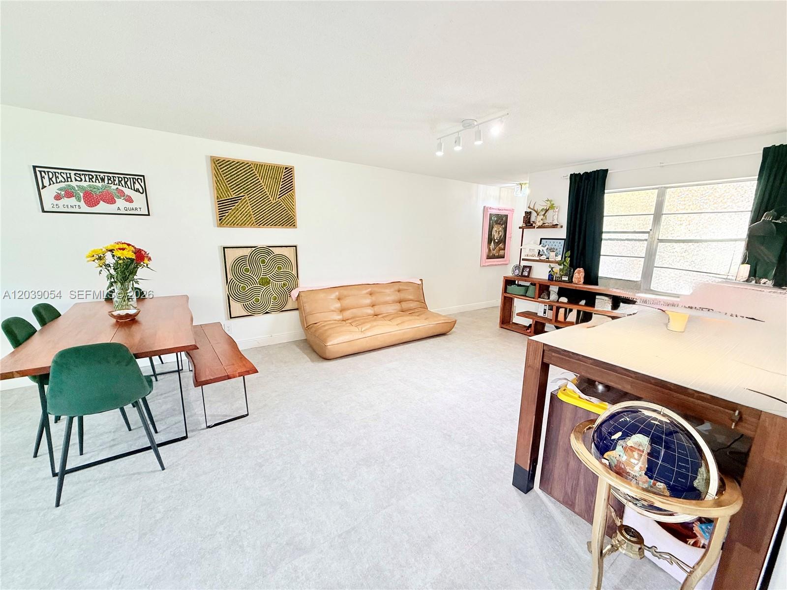 A bright, open-concept living and dining area features light tile floors and modern furniture — 1722 Mayo St # 105, Hollywood FL 33020, HOLLYWOOD, FL
