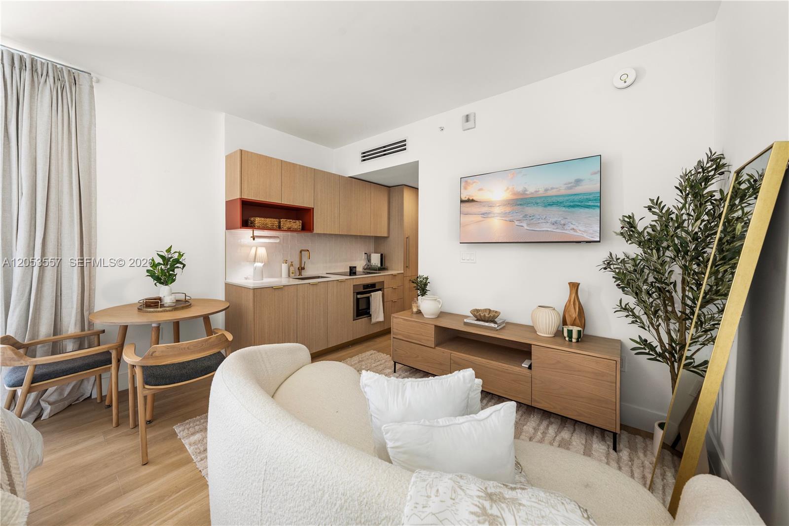 A small studio apartment features a kitchenette, dining area, and living space with neutral decor — 90 NE 32 St # 715, Miami FL 33127, MIAMI, FL