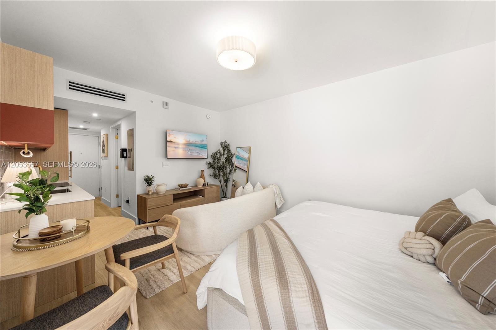 A studio apartment features a bed, a small dining area, and a television console — 90 NE 32 St # 715, Miami FL 33127, MIAMI, FL