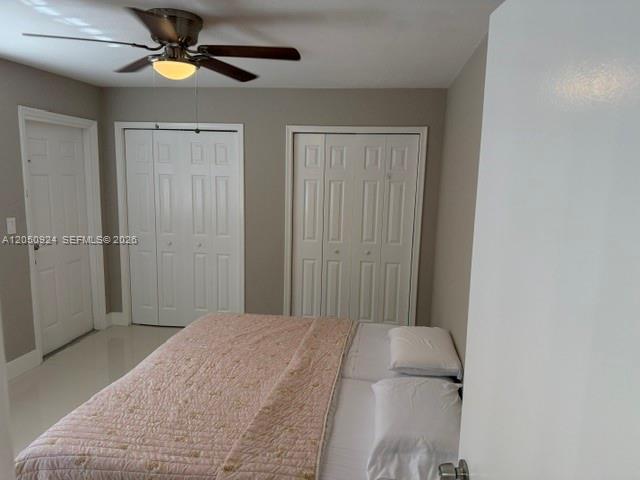 A bedroom features a ceiling fan, two sets of closet doors, and a bed — 1859 Wiley St # 3, Hollywood FL 33020, HOLLYWOOD, FL