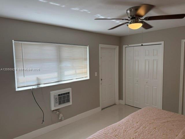 A bedroom features a window air conditioner, a ceiling fan, and white closet doors — 1859 Wiley St # 3, Hollywood FL 33020, HOLLYWOOD, FL