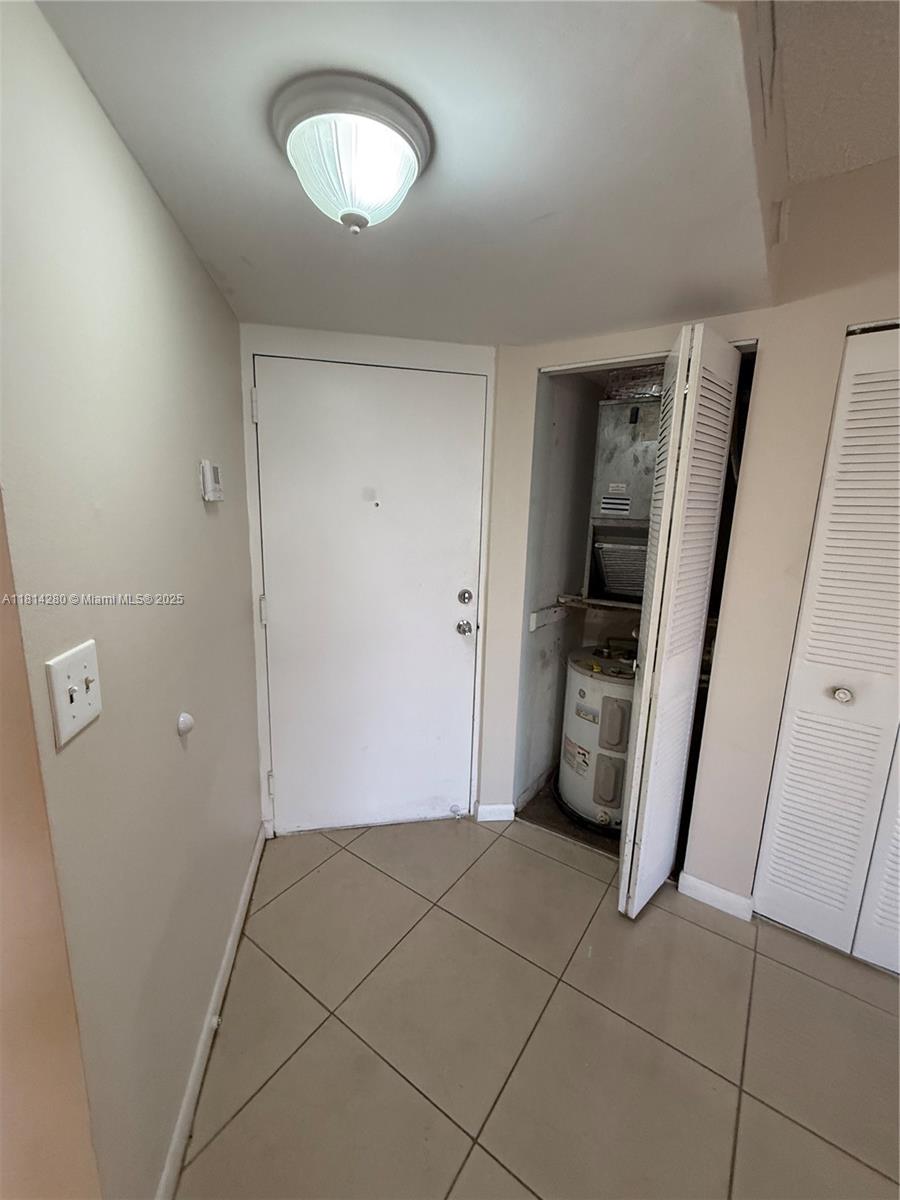 A tiled entryway features a white door, a ceiling light, and an open utility closet — 8255 SW 152 AV # 2, Miami FL 33193, MIAMI, FL