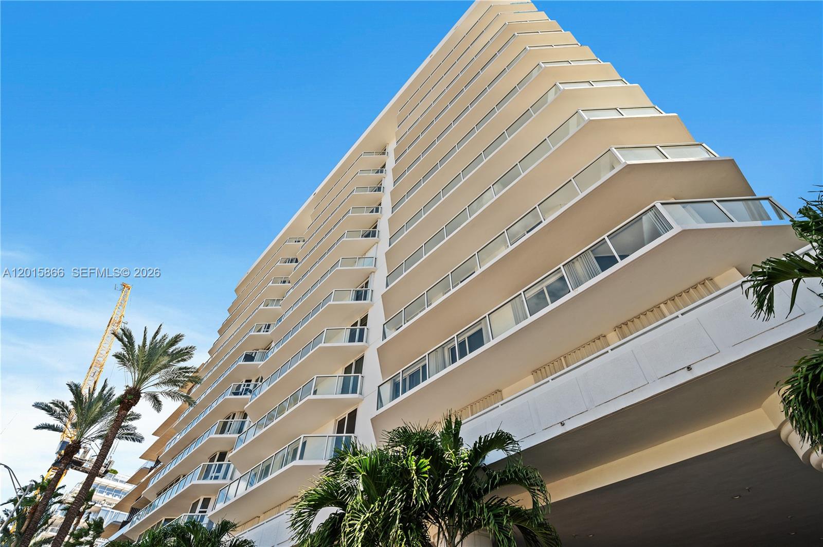 A low-angle view shows the exterior of a multi-story residential building with glass balconies — 8925 Collins Ave # 9J, Surfside FL 33154, SURFSIDE, FL