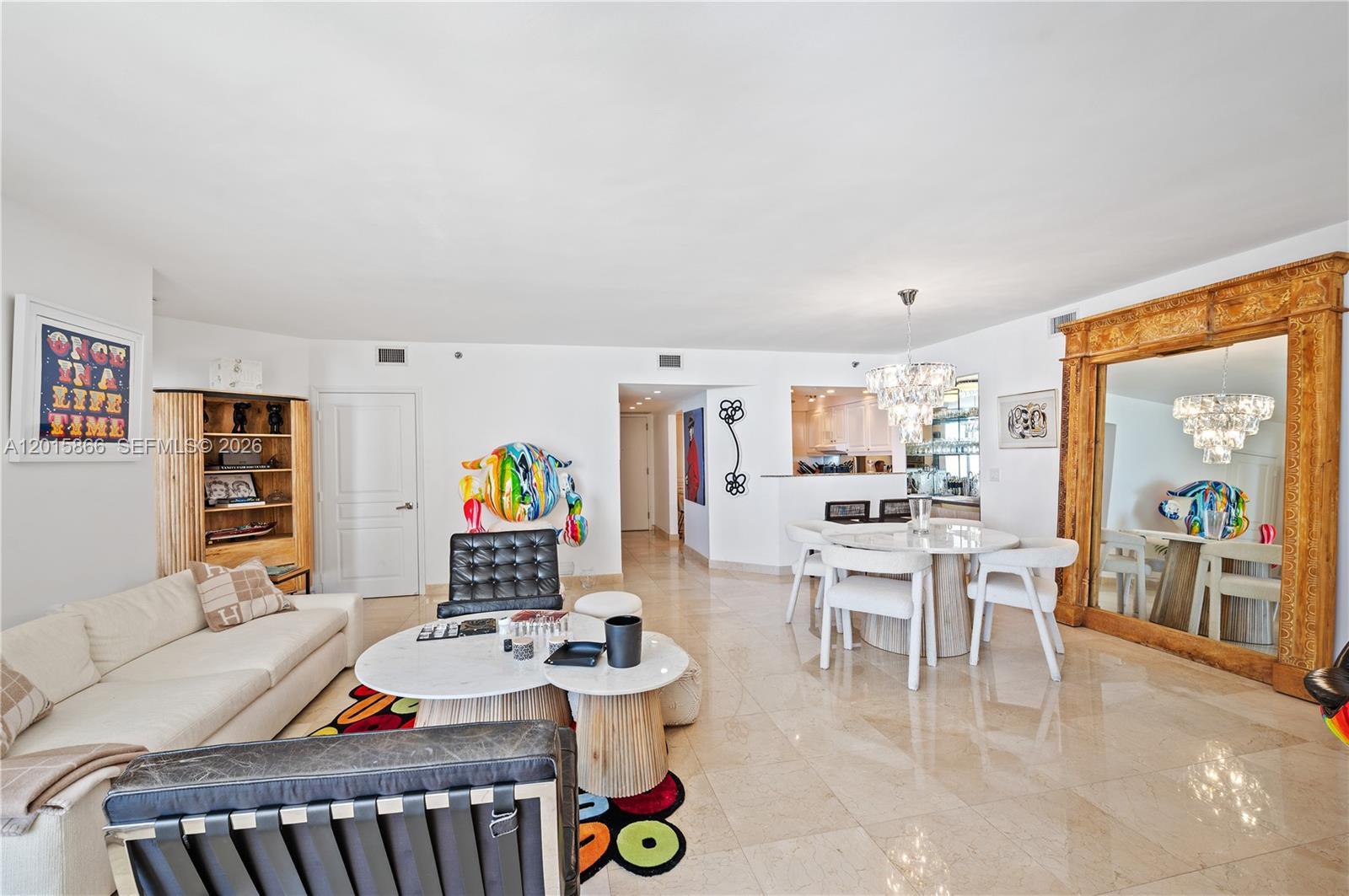 A living and dining area features white tile floors, a large mirror, and modern furniture — 8925 Collins Ave # 9J, Surfside FL 33154, SURFSIDE, FL