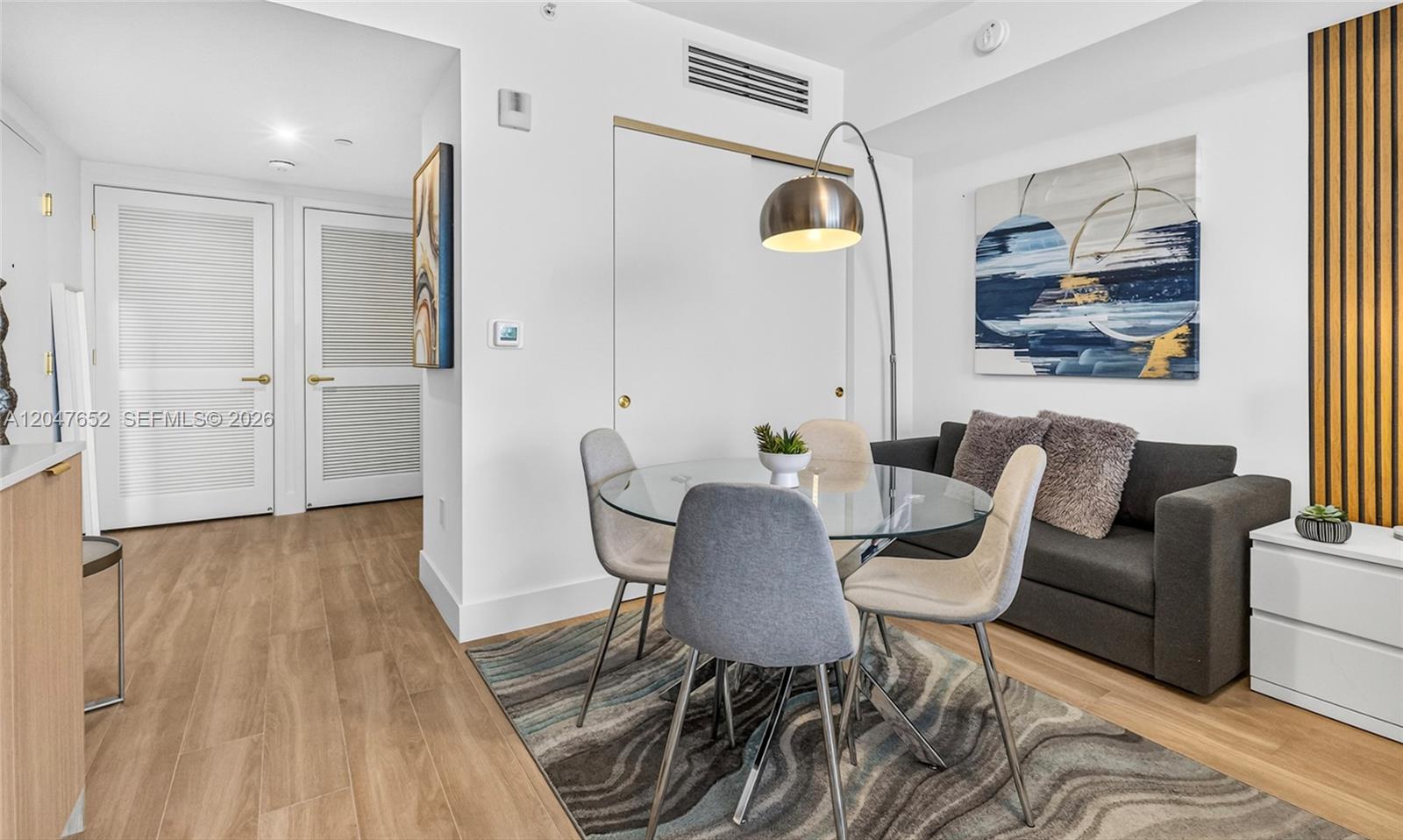 A dining area features a glass table, four chairs, a floor lamp, and a sofa — 90 NE 32 St # 613, Miami FL 33137, MIAMI, FL