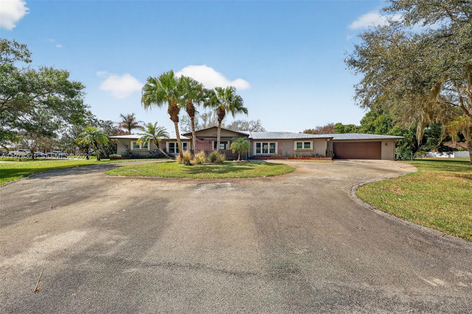 A single-story house with a circular driveway, palm trees, and a two-car garage — 5541 Teal Ter, Fort Pierce FL 34982, FORT PIERCE, FL