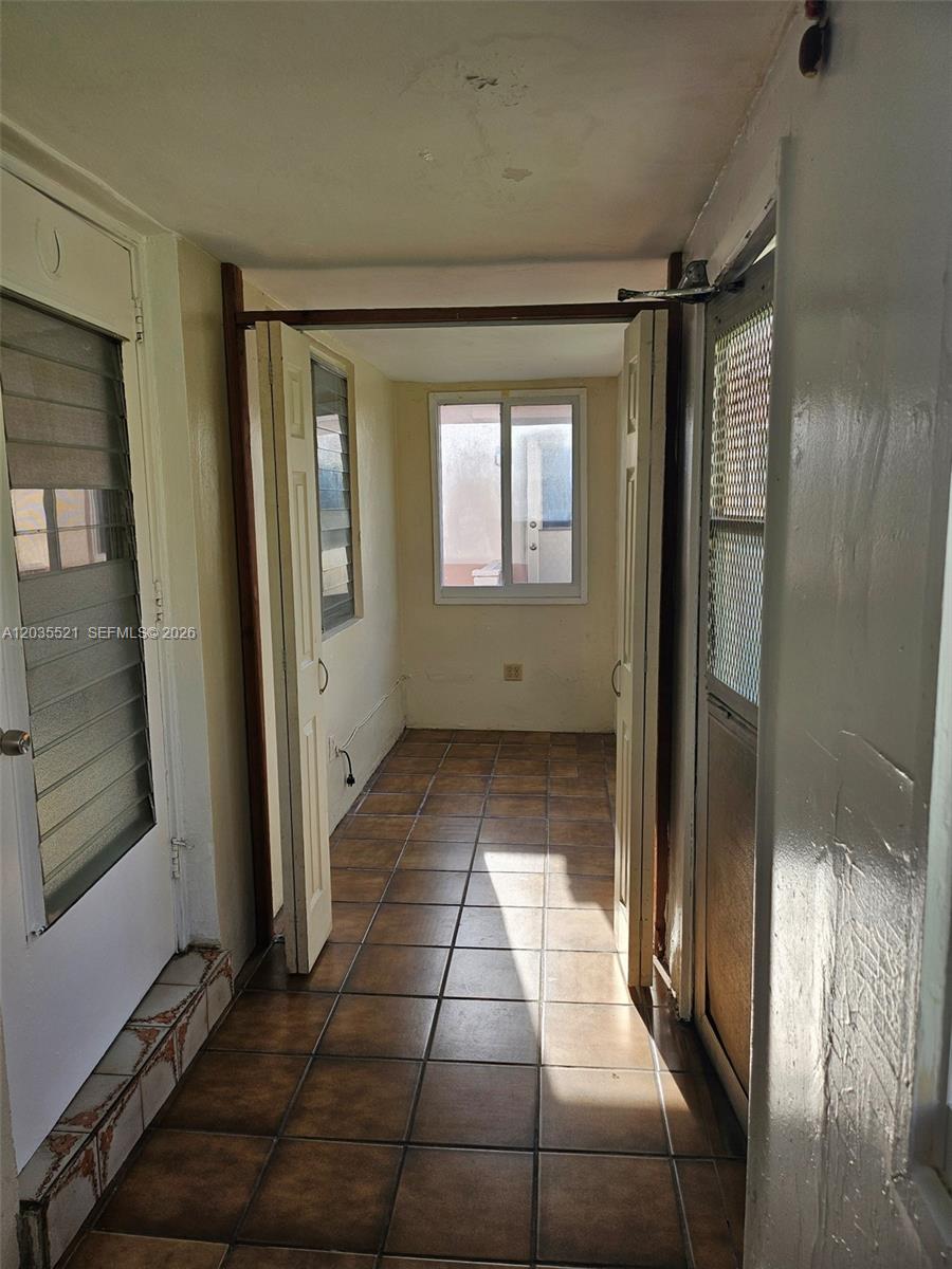 A narrow, tiled hallway leads to a small room with a window and open doors — 709 NE 4th Ct # 6, Hallandale Beach FL 33009, HALLANDALE BEACH, FL