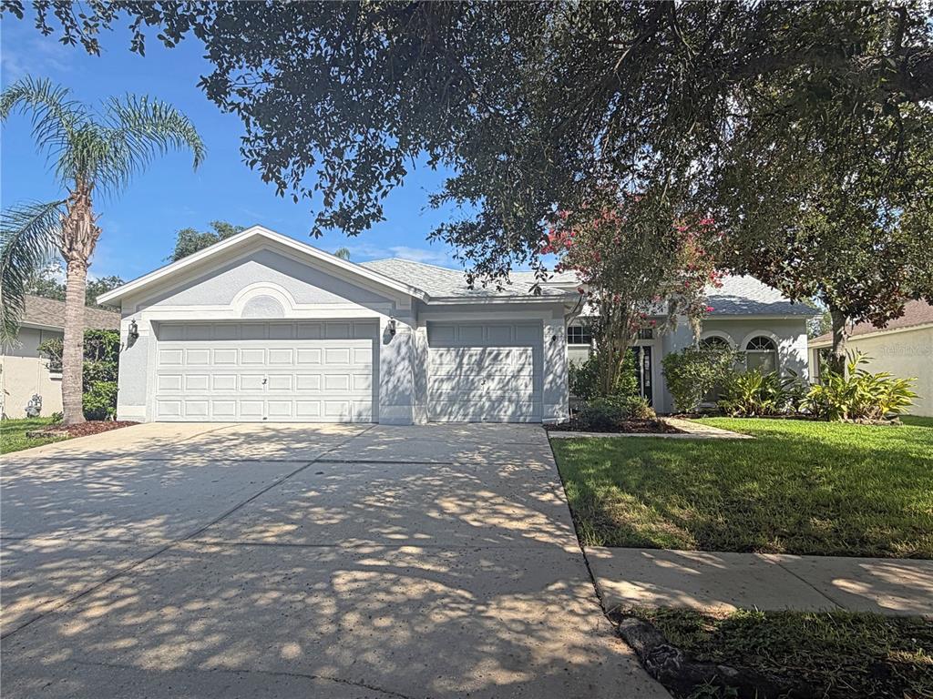 A light blue single-story house with a two-car garage and a concrete driveway — 14832 HERONGLEN DRIVE, LITHIA, FL