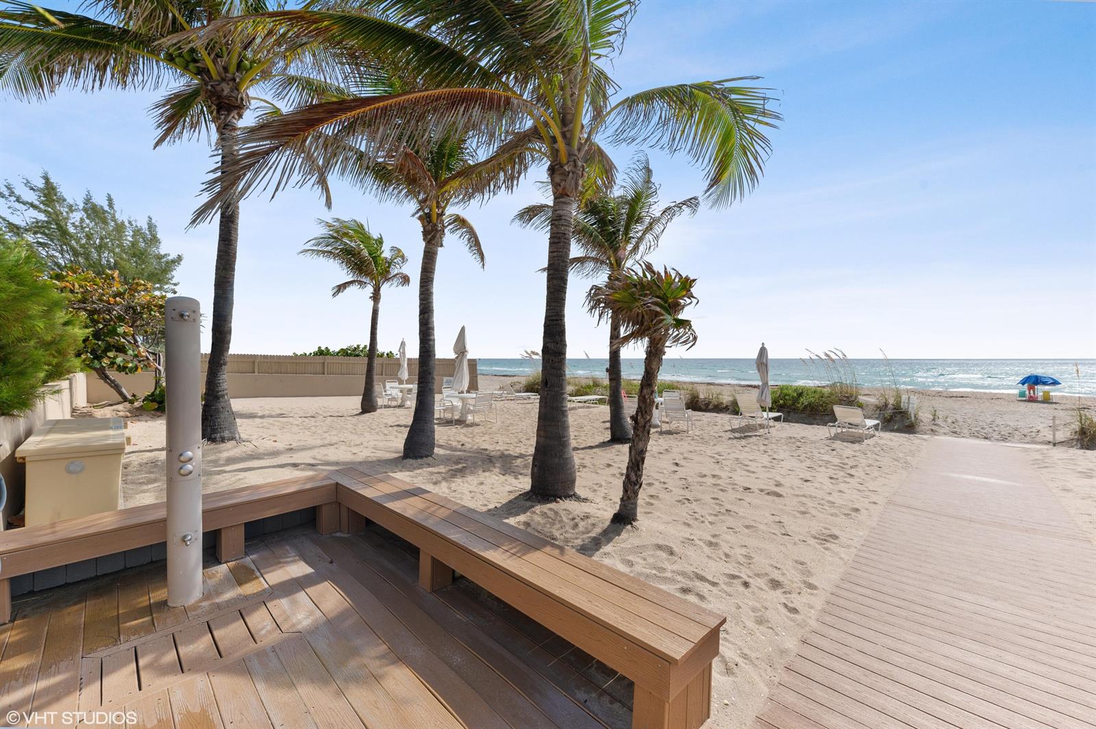 A wooden deck with a shower and bench overlooks a sandy beach with palm trees — 170 N Ocean Boulevard # 305, Palm Beach FL 33480, PALM BEACH, FL