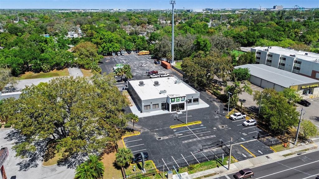 An aerial view shows a commercial building with a parking lot and surrounding trees — 2304 E BUSCH BOULEVARD, TAMPA, FL