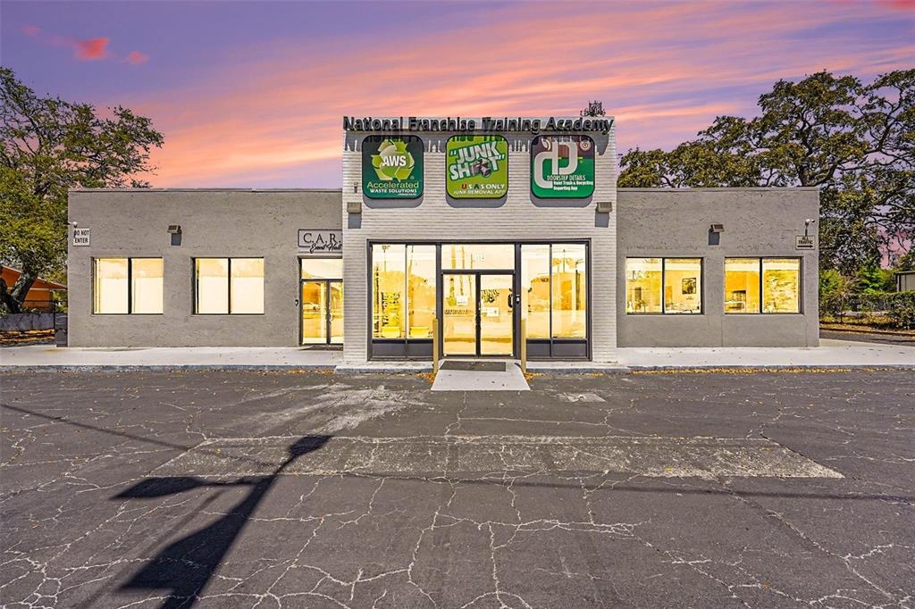 A single-story commercial building with a gray facade and three business signs above the entrance — 2304 E BUSCH BOULEVARD, TAMPA, FL