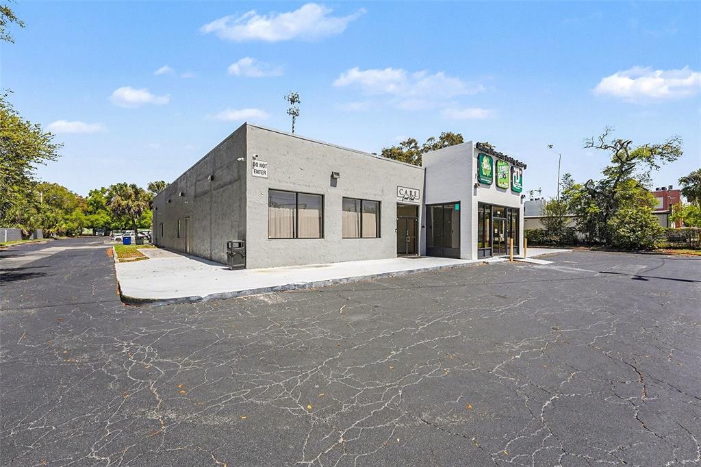 A gray commercial building with a paved parking lot under a blue sky — 2304 E BUSCH BOULEVARD, TAMPA, FL