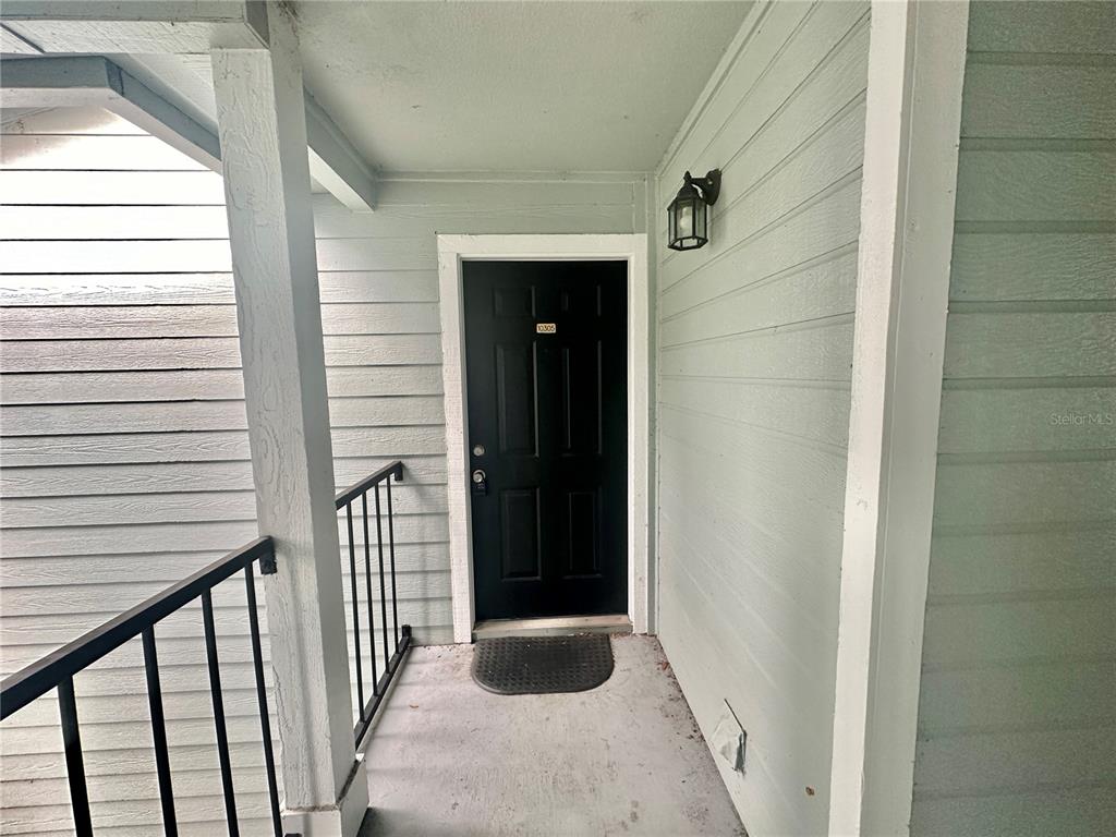 A black front door with a small number plate is centered on a covered porch — 2550 N ALAFAYA TRAIL UNIT 10305, ORLANDO, FL